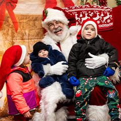 Santa Claus laughing with children on his lap