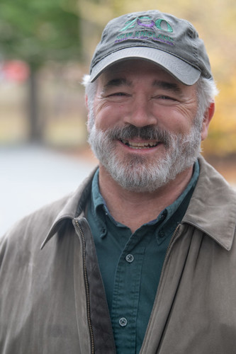 photo of smiling man with gray beard wearing gray ballcap emblazoned with Zoo New England logo